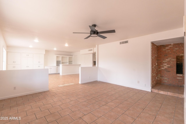 spare room with ceiling fan and light tile patterned flooring