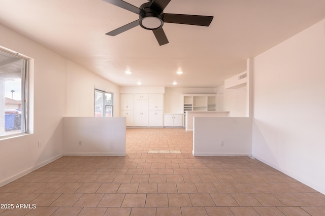 tiled empty room featuring ceiling fan