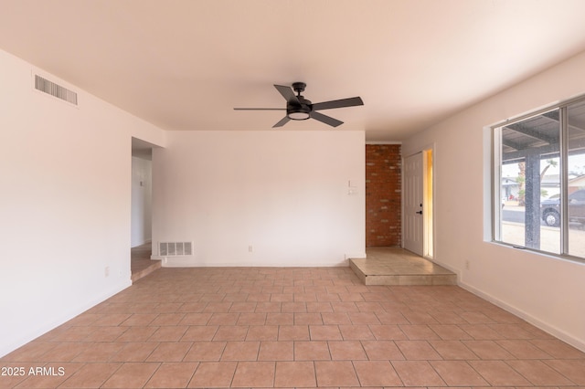 tiled spare room featuring ceiling fan