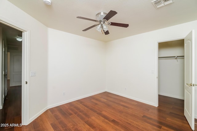 unfurnished bedroom with ceiling fan, a closet, and dark hardwood / wood-style floors