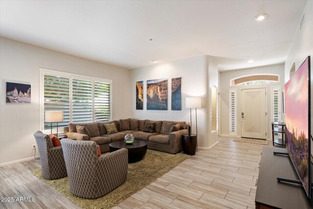 7979 E Princess Dr Unit 13, Scottsdale, AZ 85255 - living room featuring wine cooler, a bar, light wood-style floors, a ceiling fan, and a stone fireplace