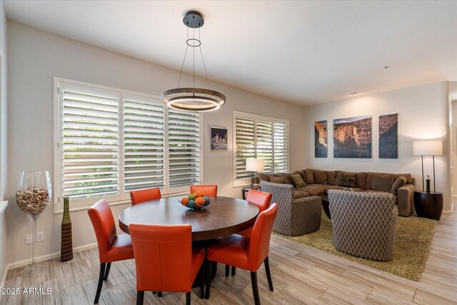 7979 E Princess Dr Unit 13, Scottsdale, AZ 85255 - dining room featuring a fireplace, arched walkways, wood finished floors, and plenty of natural light