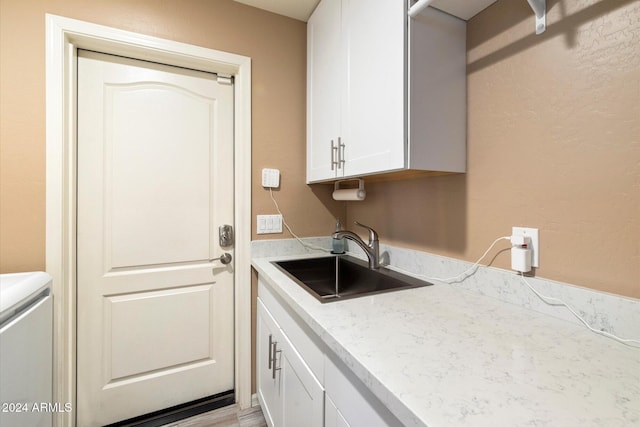 washroom featuring light hardwood / wood-style floors, cabinets, and sink