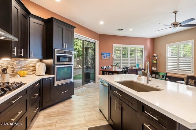 kitchen with a center island with sink, plenty of natural light, sink, and stainless steel appliances