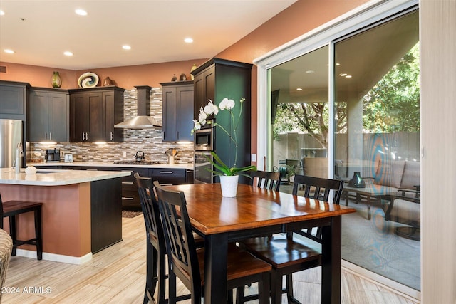 dining area featuring light wood-type flooring, plenty of natural light, and sink