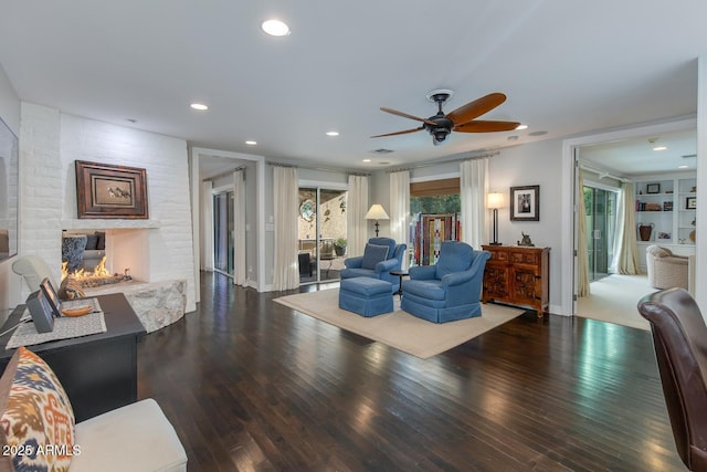 living room featuring hardwood / wood-style floors, a fireplace, and ceiling fan