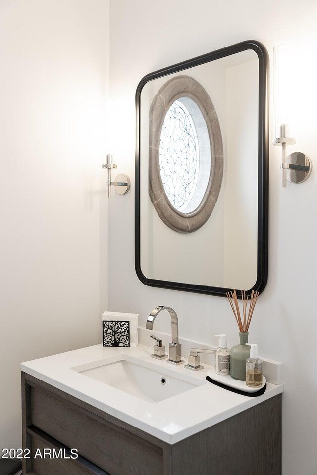 bathroom featuring tile patterned flooring, vanity, and a washtub