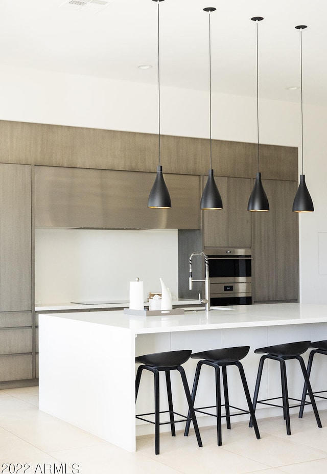 kitchen with pendant lighting, a breakfast bar area, and double oven