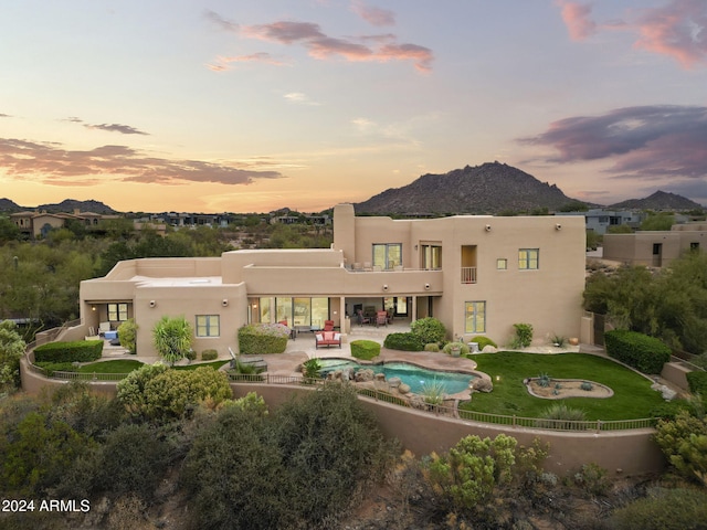 back house at dusk featuring a mountain view, an outdoor hangout area, and a patio