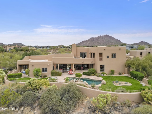 rear view of property featuring a mountain view, a patio area, and an outdoor hangout area