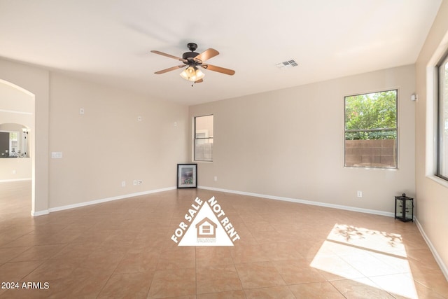 tiled spare room featuring ceiling fan