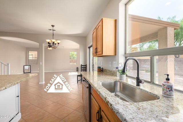 kitchen with dishwasher, sink, decorative light fixtures, light tile patterned floors, and a notable chandelier