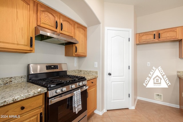 kitchen featuring light stone counters, stainless steel range with gas cooktop, and light tile patterned floors