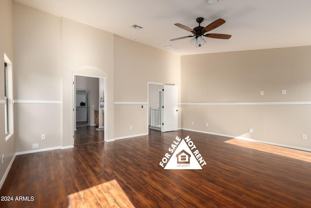 spare room featuring ceiling fan, dark hardwood / wood-style flooring, and a high ceiling