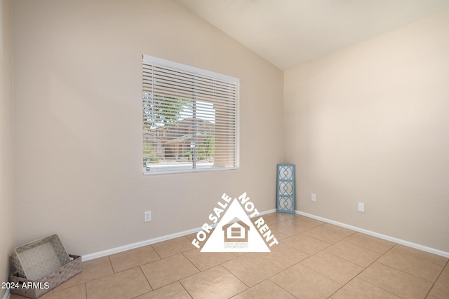 tiled spare room with vaulted ceiling