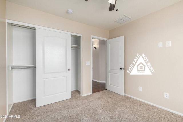 unfurnished bedroom with ceiling fan, a closet, and light colored carpet