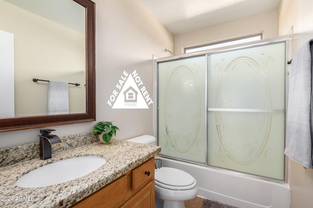 full bathroom with vanity, bath / shower combo with glass door, and toilet