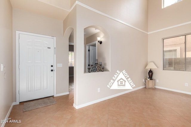 tiled entryway featuring a high ceiling