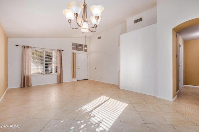 unfurnished room with light tile patterned floors, vaulted ceiling, and a notable chandelier