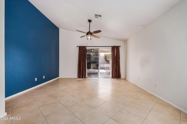 tiled empty room featuring vaulted ceiling and ceiling fan