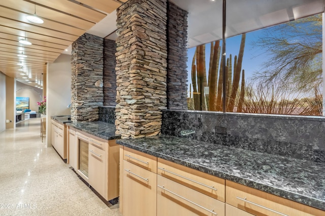 39602 N Charles Blair Macdonald Rd, Scottsdale, AZ 85262 - kitchen with arched walkways, granite floors, dark stone countertops, decorative backsplash, and light brown cabinetry