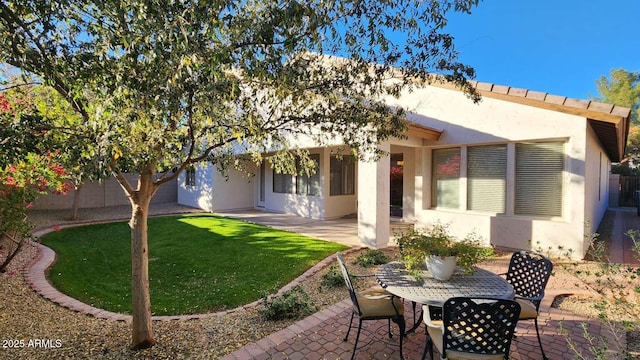 rear view of property featuring a yard and a patio area