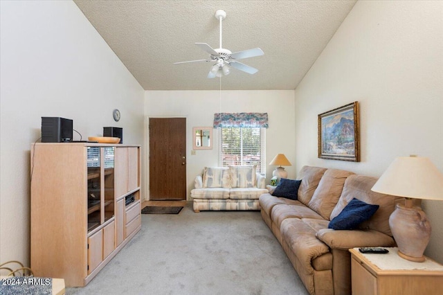 living room featuring ceiling fan, a textured ceiling, lofted ceiling, and light carpet