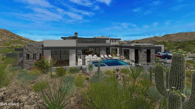 back of property with a mountain view and a patio area