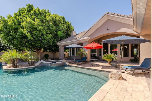 view of pool featuring a pool with connected hot tub, fence private yard, and a patio area