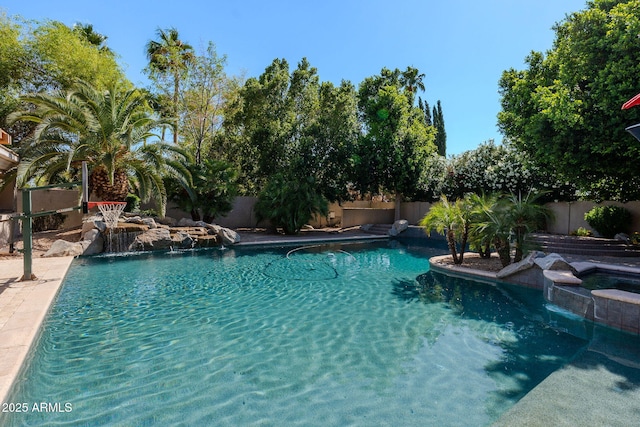 view of pool featuring a pool with connected hot tub and a fenced backyard
