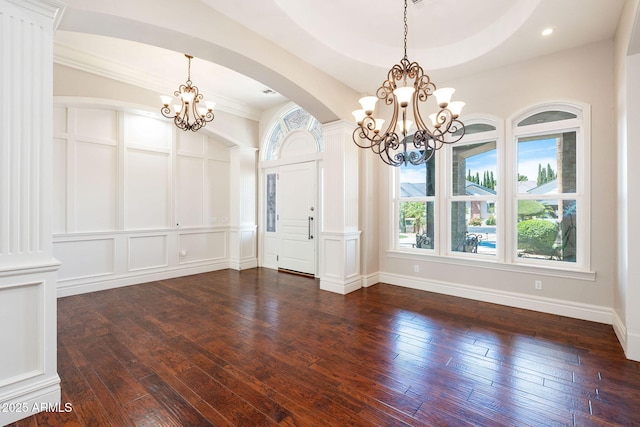 unfurnished dining area featuring plenty of natural light, a chandelier, and dark wood-type flooring