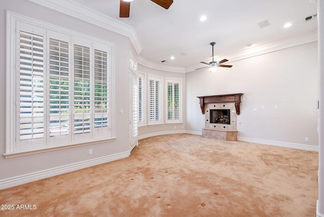 unfurnished living room with a tiled fireplace, carpet floors, a ceiling fan, and visible vents