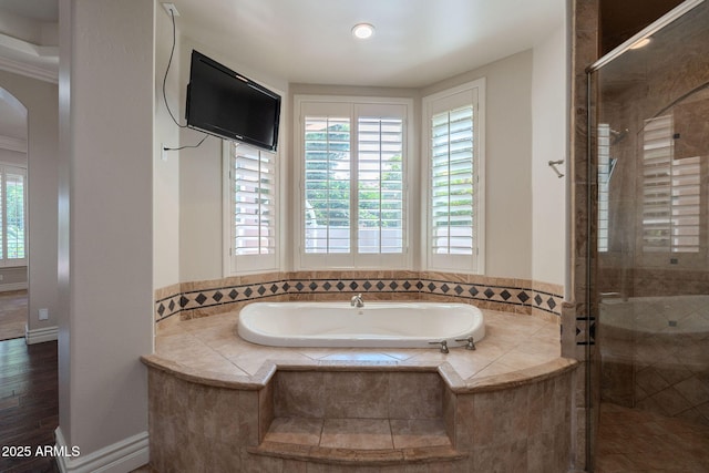 full bathroom featuring a stall shower, a garden tub, and plenty of natural light