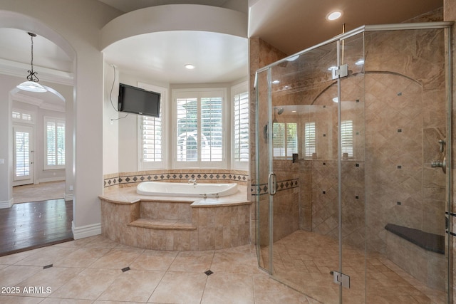 bathroom with a shower stall, a wealth of natural light, ornamental molding, and a bath