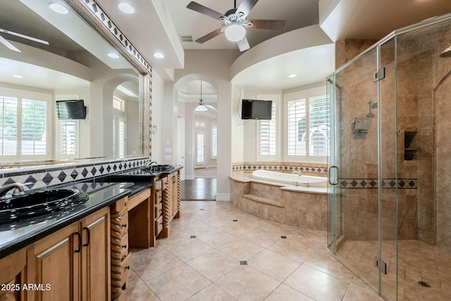 bathroom with a ceiling fan, visible vents, a bath, and a shower stall