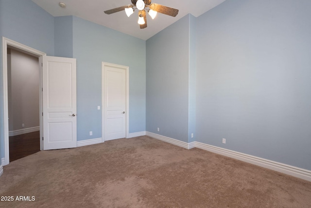 unfurnished bedroom featuring baseboards, a ceiling fan, carpet, and high vaulted ceiling