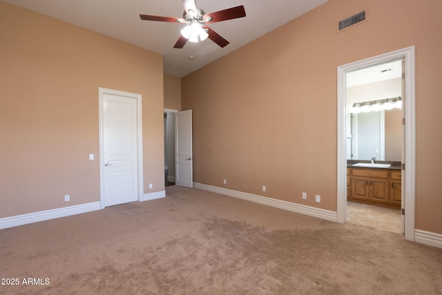 unfurnished bedroom with baseboards, light carpet, visible vents, and high vaulted ceiling