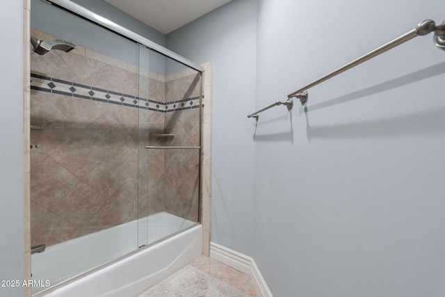 full bath with combined bath / shower with glass door, baseboards, and tile patterned floors