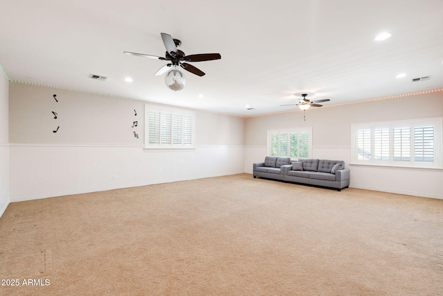 living area with a wainscoted wall and a ceiling fan