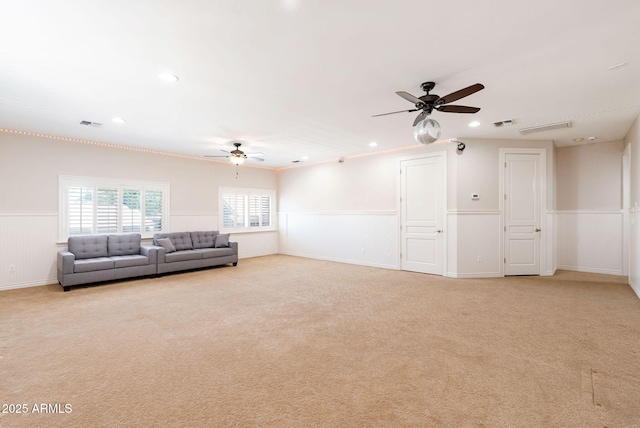 living room with a ceiling fan, visible vents, wainscoting, light colored carpet, and recessed lighting
