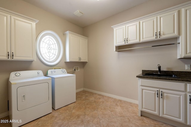 clothes washing area with washing machine and clothes dryer, a sink, cabinet space, and baseboards