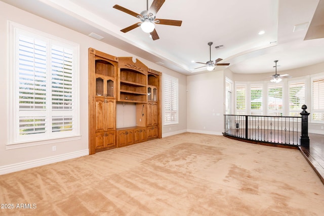unfurnished living room featuring baseboards, visible vents, ceiling fan, and light colored carpet