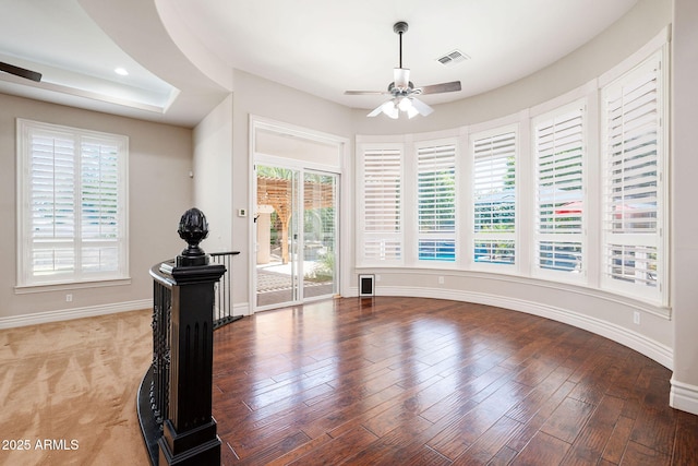 interior space with wood finished floors, visible vents, baseboards, and a ceiling fan