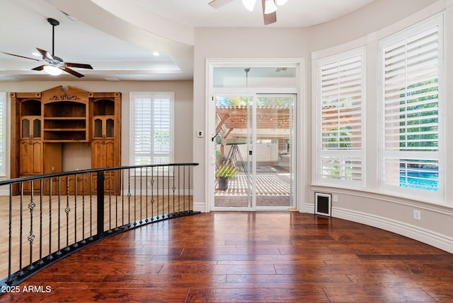 spare room with baseboards, wood-type flooring, and ceiling fan