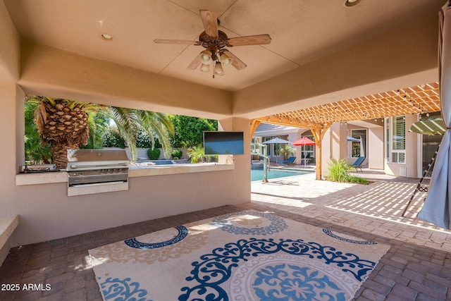 view of patio featuring an outdoor kitchen, an outdoor pool, ceiling fan, and grilling area