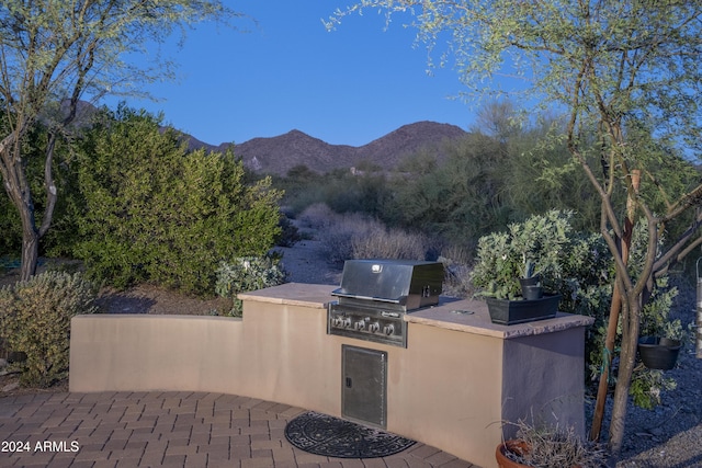 view of patio with a mountain view, a grill, and exterior kitchen