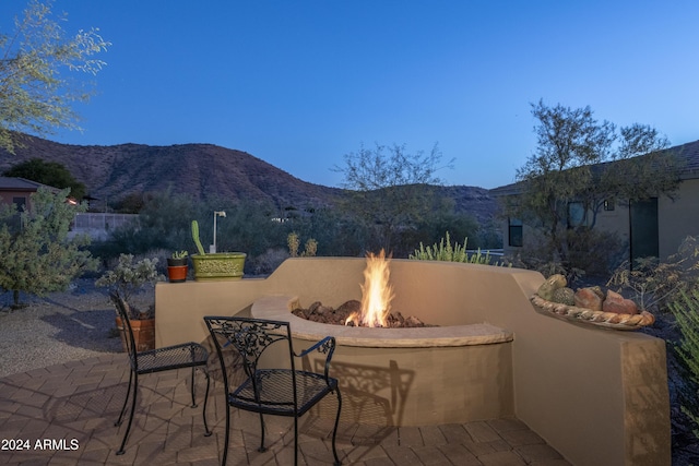 view of patio / terrace with a mountain view and an outdoor fire pit