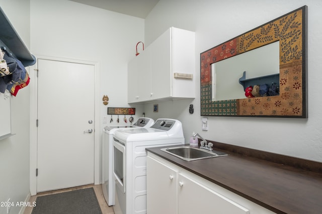 laundry room featuring light tile patterned flooring, cabinets, separate washer and dryer, and sink