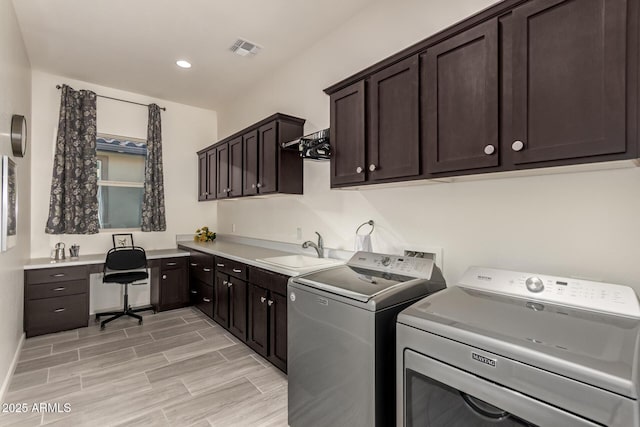 laundry area featuring sink, washer and clothes dryer, and cabinets