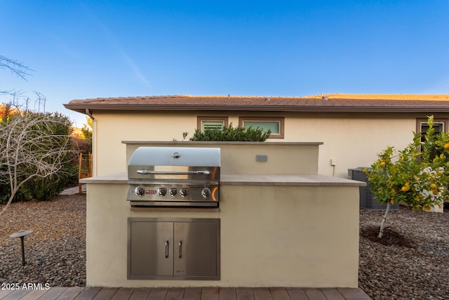 view of patio / terrace with central AC, a grill, exterior kitchen, and a deck